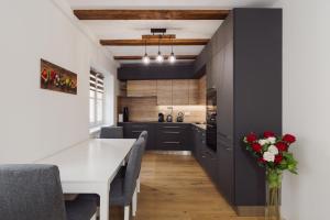 a kitchen with black cabinets and a white table at Prague Old Town Liliova Garden in Prague