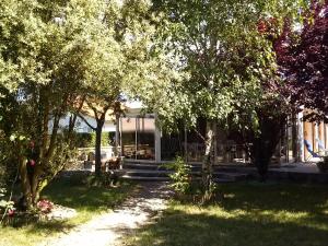 un jardín con árboles y un edificio de fondo en Villa de vacances bord de mer, en Meschers-sur-Gironde