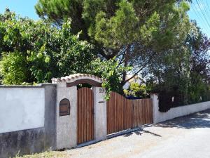 una valla con una puerta de madera en Villa de vacances bord de mer, en Meschers-sur-Gironde