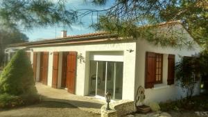 Casa blanca con una gran puerta de cristal en Villa de vacances bord de mer, en Meschers-sur-Gironde