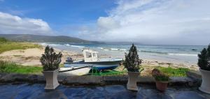 un barco sentado en la playa junto al océano en La Casa de Ana en Fisterra, en Finisterre
