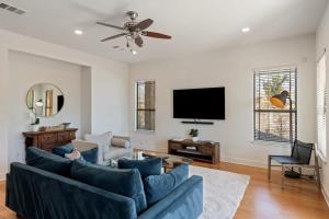 a living room with a blue couch and a flat screen tv at Bright Home in East ATX - 3BR - Cowboy Pool in Austin