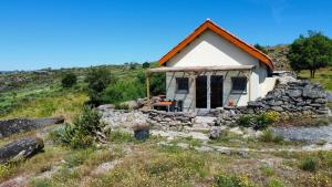 a small house on a hill with a stone wall at Quinta da Estrela in Ponte Nova