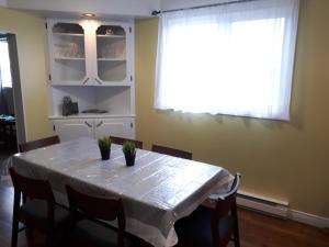 a dining room with a table with chairs and a window at Lands End Vacation Home in Twillingate