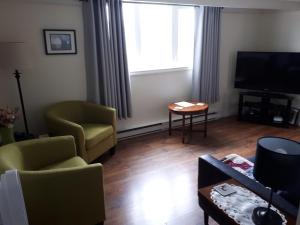 a living room with two chairs and a television at Lands End Vacation Home in Twillingate