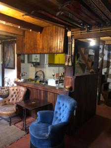 a living room with a blue chair and a table at Chalé na Montanha Casa de Baixo in Manteigas