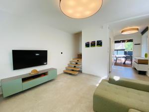 a living room with a couch and a flat screen tv at PS36 Holiday Home Siófok in Siófok