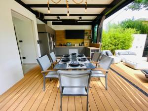 a dining room with a table and chairs on a deck at PS36 Holiday Home Siófok in Siófok