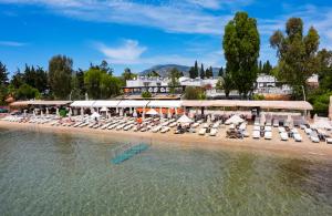 a beach with chairs and umbrellas next to the water at Manuela Boutique Hotel Bitez in Bitez