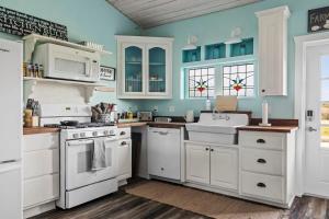 a kitchen with white appliances and blue walls at Kingsby Cottage - 1 Bedroom w Mountain views in Boerne