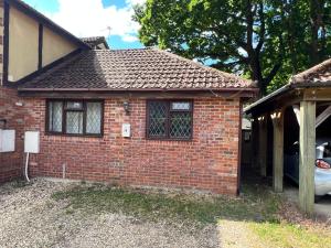 ein Backsteinhaus mit einem Auto in der Einfahrt in der Unterkunft 1a Woodlands Edge in Trowbridge