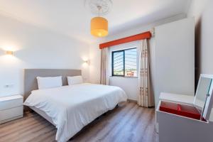 a bedroom with a white bed and a window at Solgarve in Quarteira