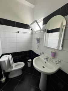 a bathroom with a toilet and a sink and a mirror at Villa Shehu in Ksamil