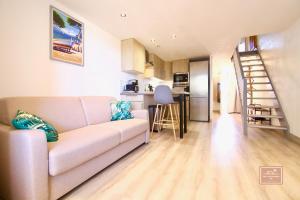 a living room with a couch and a kitchen at La Digue, 2 chambres, vue mer et piscine in La Seyne-sur-Mer