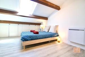 a bedroom with a bed with a blue comforter at La Digue, 2 chambres, vue mer et piscine in La Seyne-sur-Mer +24 photos