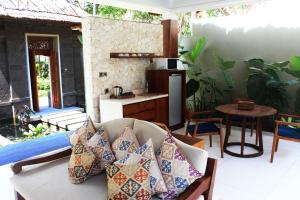 a living room with a couch with pillows on it at Regali Villa Canggu in Canggu