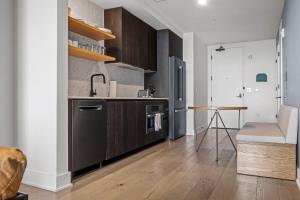 a kitchen with wooden cabinets and a table in it at Modern 1BR Condo on Rainey St with Pool and Views in Austin +18 photos