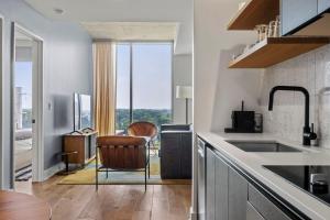 a kitchen with a sink and a chair in it at Modern 1BR Condo on Rainey St with Pool and Views in Austin