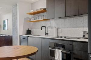 a kitchen with a table and a sink and a stove at Modern 1BR Condo on Rainey St with Pool and Views in Austin