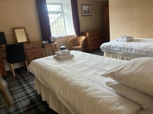 a hotel room with two beds and a window at Aleppo Merchant Inn in Carno