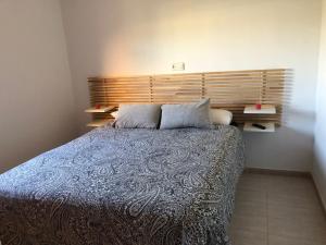 a bedroom with a large bed with a wooden headboard at Harea Coastal Penthouse Naturist Area in Playas de Vera +7 photos