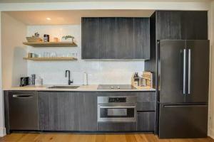 Una cocina con frigorífico de acero inoxidable y fregadero. en High Rise in the heart of ATX, en Austin