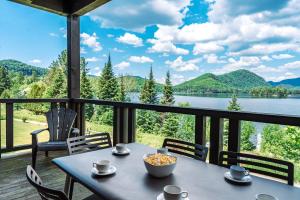 a table on a porch with a view of a lake at Lake Resort Suite: Views & Amenities in Lac-Superieur