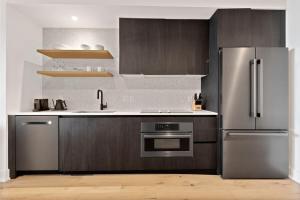 a kitchen with a stainless steel refrigerator and a sink at Luxe Condo in Downtown Austin in Austin