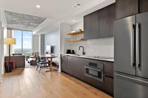 a kitchen with a stainless steel refrigerator and a table at Luxe Condo in Downtown Austin in Austin