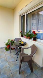 a patio with two chairs and a table and a window at Arianna Apartman in Miskolc