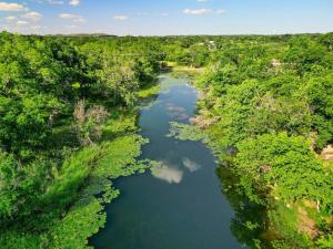 an aerial view of a river in a forest at Waterlily Creekside Serenity in Wimberley
