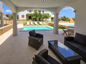 a patio with furniture and a swimming pool at La Casa di Emy in Budoni