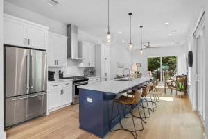 eine Küche mit weißen Schränken und eine blaue Insel mit Stühlen in der Unterkunft Home in Cherrywood with Private Backyard in Austin