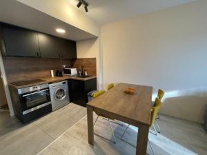 a kitchen with a table and a stove and a microwave at Lake and Spa Apartman in Velence