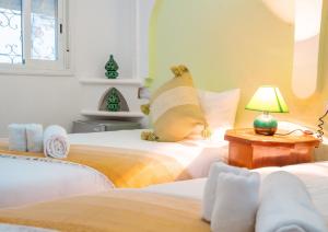 a bedroom with two beds and a lamp on a table at Dar Ibn Battouta - Volubilis Room in Tangier