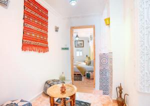 a room with a table and a living room at Dar Ibn Battouta - Volubilis Room in Tangier +4 photos