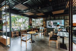 a restaurant with tables and chairs and a large screen at Holiday Inn San Salvador, an IHG Hotel in San Salvador