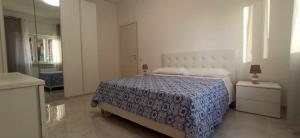 a bedroom with a bed with a blue comforter at Rome's Beach Sweet Home in Torvaianica