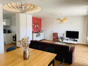 a living room with a table and a dining room at Spacious Near Center Terrace et Parking in Rennes +9 photos