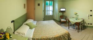 ein Schlafzimmer mit einem Bett, einem Tisch und einem Tisch in der Unterkunft Agriturismo Maso Giomo in Brentonico