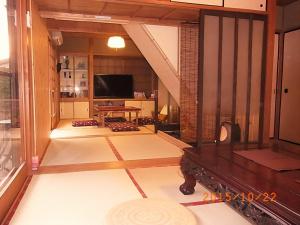 sala de estar con TV y mesa en Thank you so muchya Eikando en Kioto