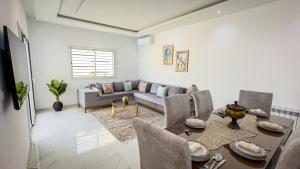 a living room with a table and a couch at Jasmin Villas Djerba in Mezraya