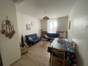 salon ze stołem i kanapą w obiekcie Les Platanes - Renoir Rez de chaussée w mieście Lamalou-les-Bains