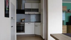 a kitchen with white cabinets and a stove at Ferienwohnung mit Parkplatz und Terrasse in Boppard