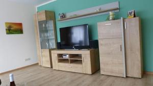 a living room with a tv on a wooden entertainment center at Ferienwohnung mit Parkplatz und Terrasse in Boppard