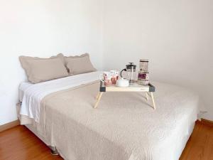 a bed with a tray with a table on it at Apartamento moderno y céntrico en Lima, 3 Dormitorios in Lima