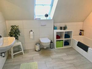 Un baño con lavabo, inodoro y bañera. en Ferienhaus Momke am Diek Haushälft A, en Simonsberg 23 fotos más