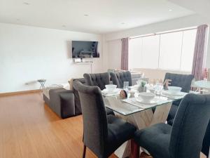 a living room with a dining table and chairs at Apartamento moderno y céntrico en Lima, 3 Dormitorios in Lima