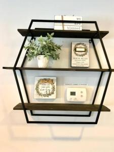 a glass shelf with a clock and a potted plant at Virginia Beach 2Story with Pool in Virginia Beach
