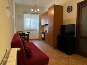 罗马Oderisi crossroads的客厅里有一张红色的沙发和一台电视